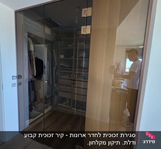 ארון עם דלתות זכוכית כהות בחדר שינה